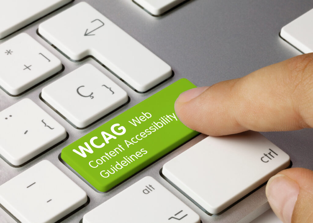 Finger pressing a green keyboard key labeled WCAG Web Content Accessibility Guidelines